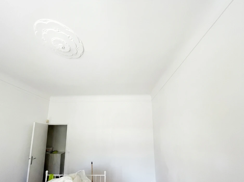 Pièce vide aux murs et plafond blancs immaculés, angle de vue depuis le bas