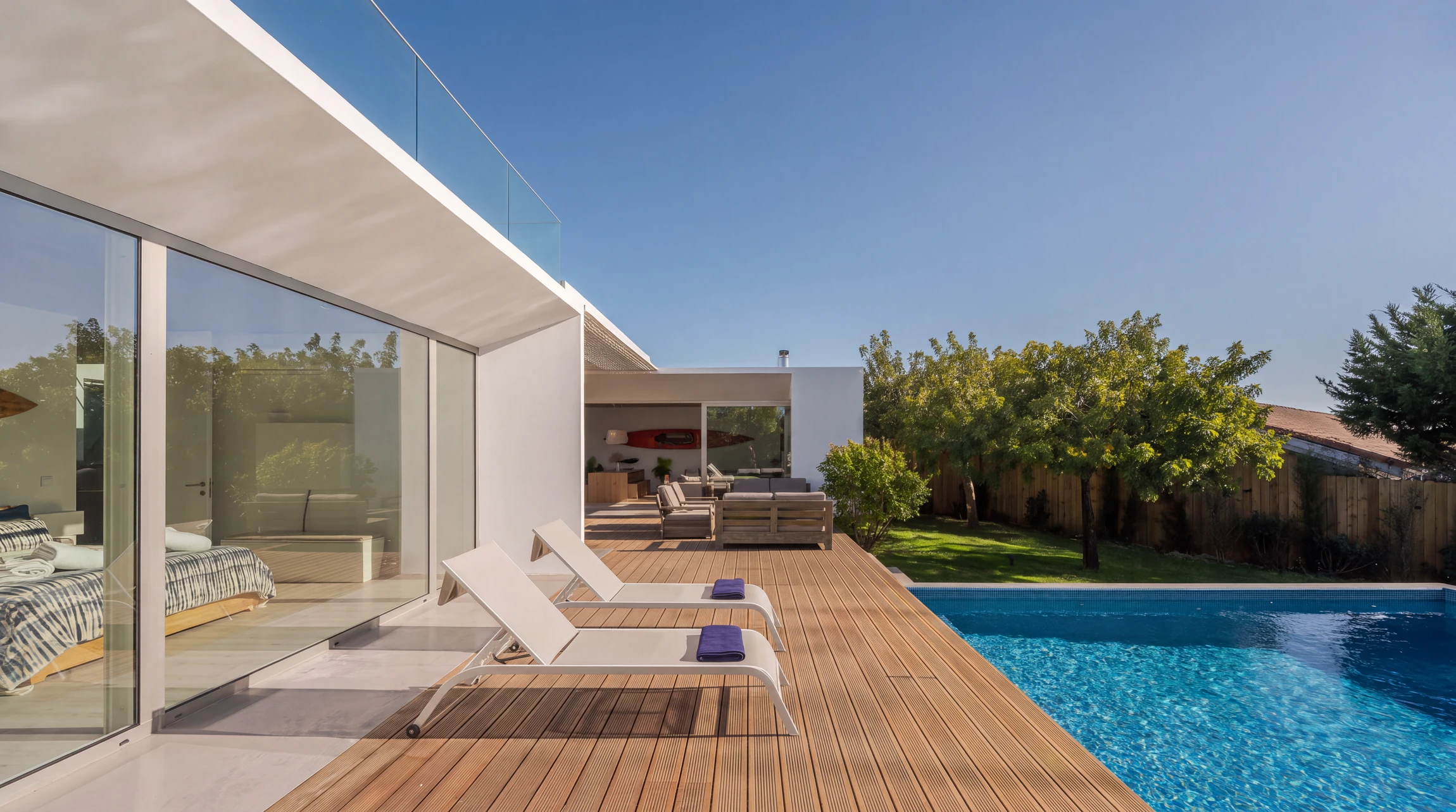 Terrasse extérieure fraîchement repeinte avec revêtement de sol PVC aspect bois, finition brillante et uniforme, montrant une transition nette entre l'ancien et le nouveau revêtement. Clôture légère en arrière-plan, espace bien délimité et professionnel.