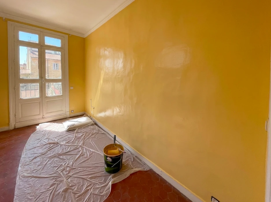 Intérieur en cours de rénovation avec échelle double en bois positionnée contre les murs